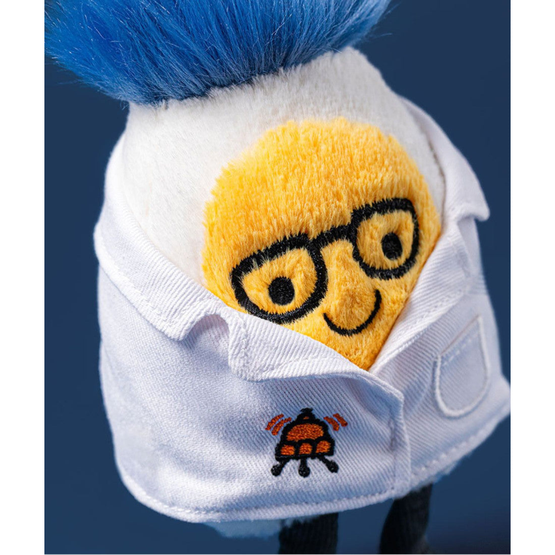 Maskotka Jellycat Amuseables – Jajko Naukowiec 14 cm, zbliżenie na okulary i fartuch, zdjęcie na granatowym tle