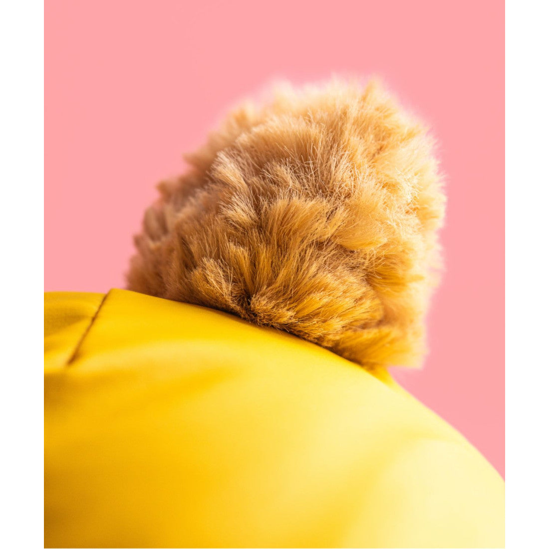 Zbliżenie na futerko w kolorze toffi i żółte ogrodniczki misia Jellycat
