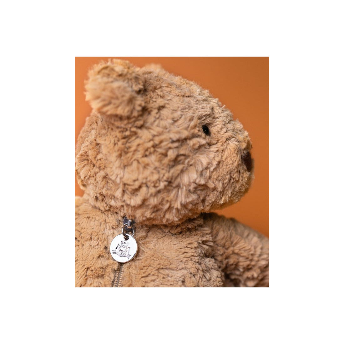Plecak Jellycat – Miś Bartłomiej 31 cm, zbliżenie na głowę misia i zawieszkę zamka