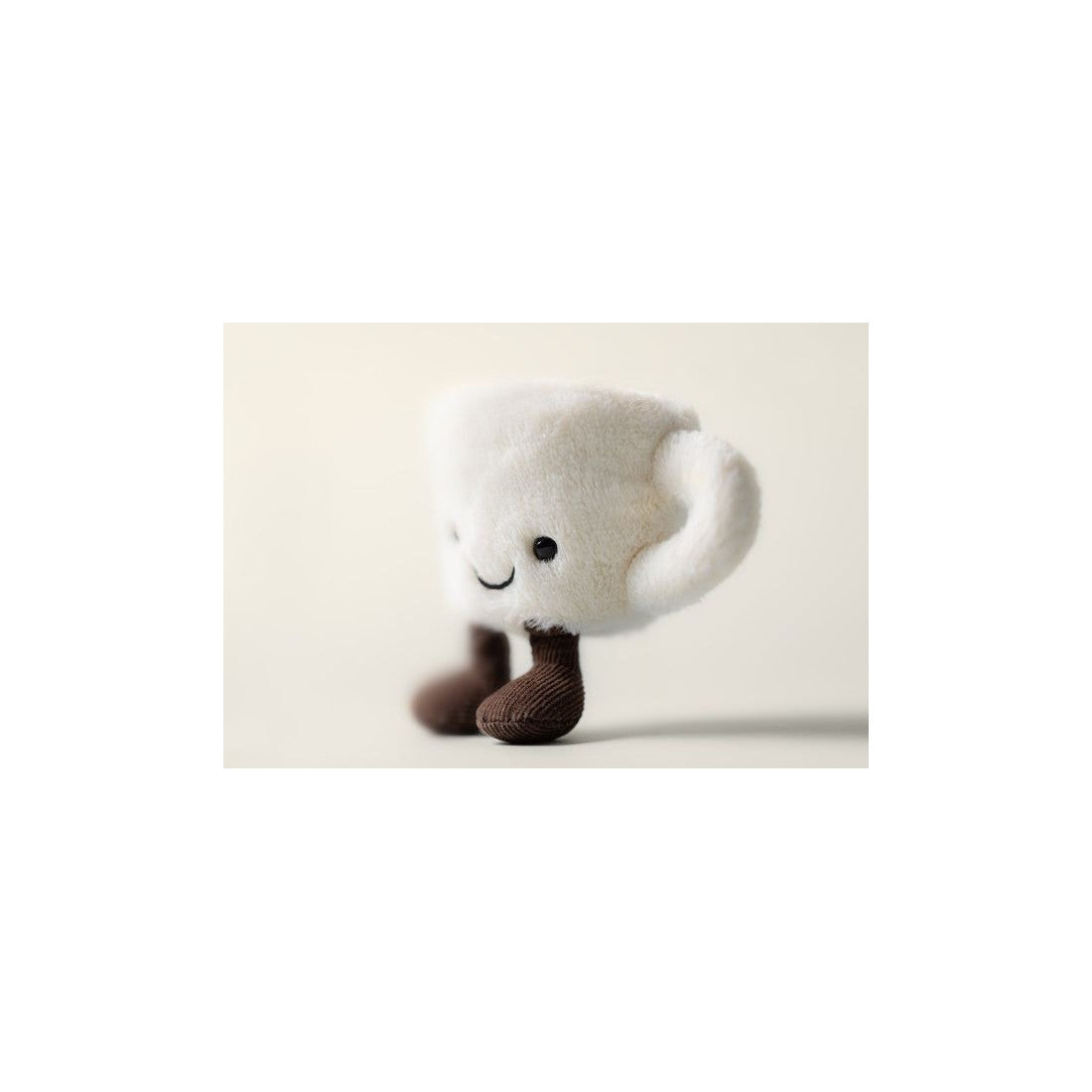 Pluszowa filiżanka espresso Jellycat z boku na jasnym tle