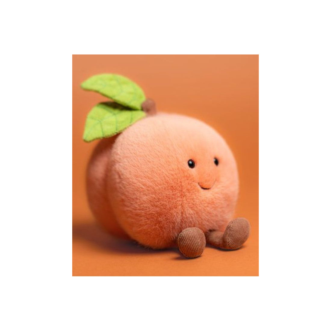 Brzoskwinia Jellycat Amuseables na pomarańczowym tle
