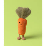 Maskotka Jellycat Amuseables – Marchewka 28 cm, na nóżkach, zdjęcie na zielonym tle