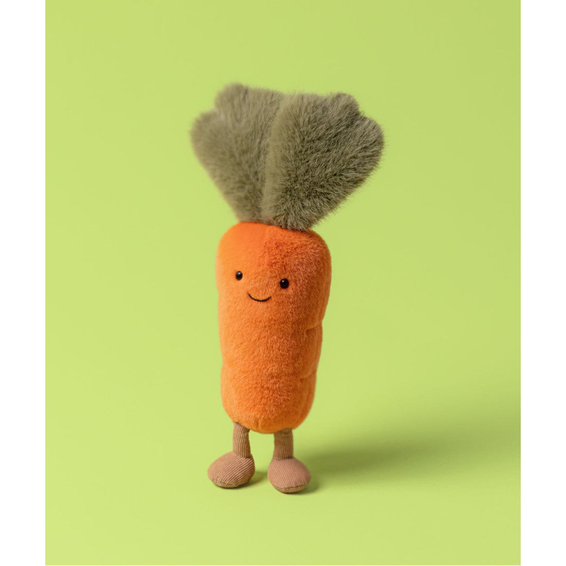 Maskotka Jellycat Amuseables – Marchewka 28 cm, na nóżkach, zdjęcie na zielonym tle