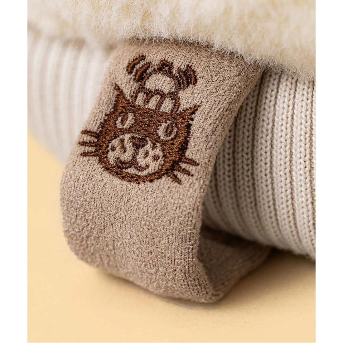 Maskotka Jellycat Amuseables – Rękawiczka 27 cm, zbliżenie na haftowaną naszywkę