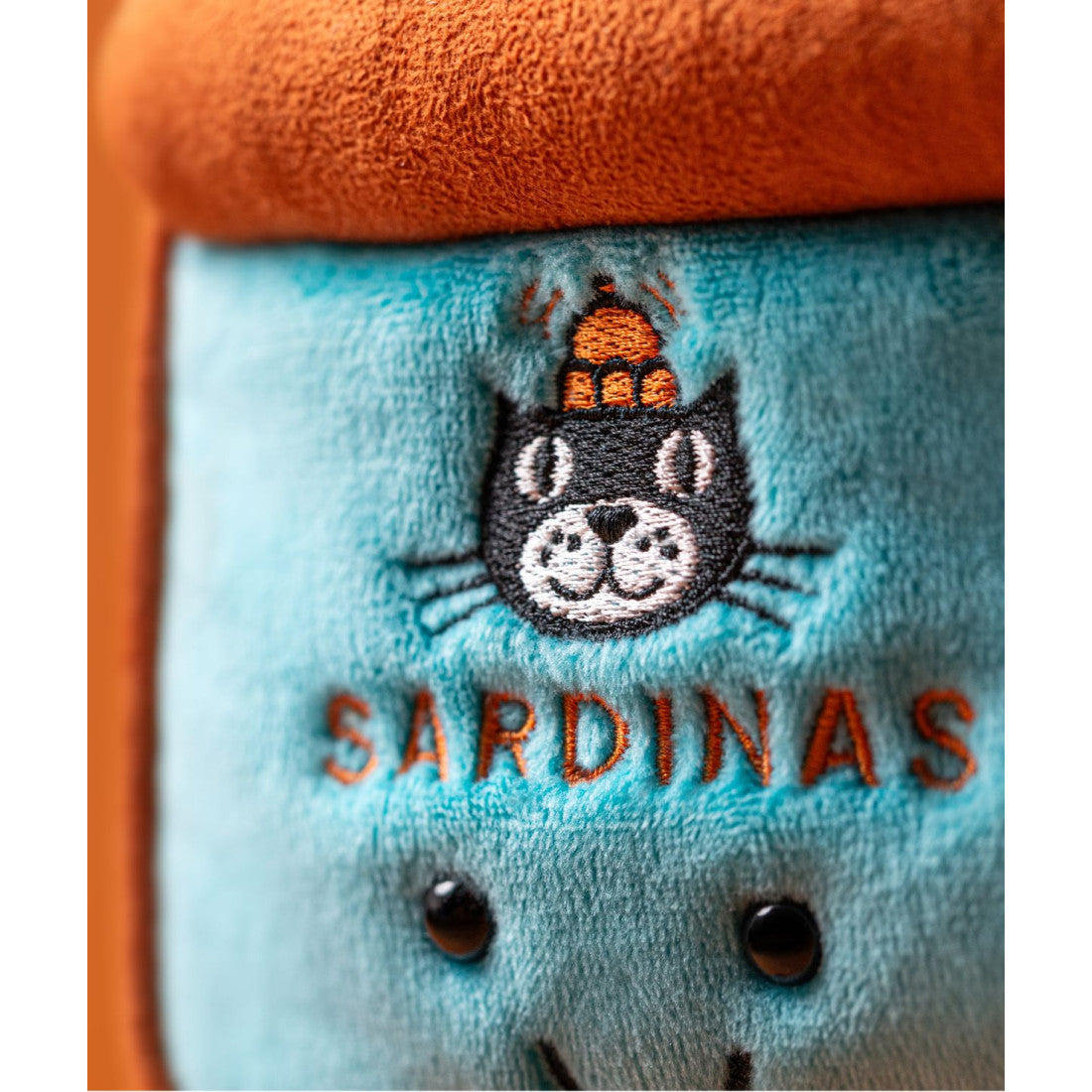 Maskotka Jellycat Amuseables – Puszka Sardynek 17 cm, zbliżenie na etykietę z napisem SARDINAS