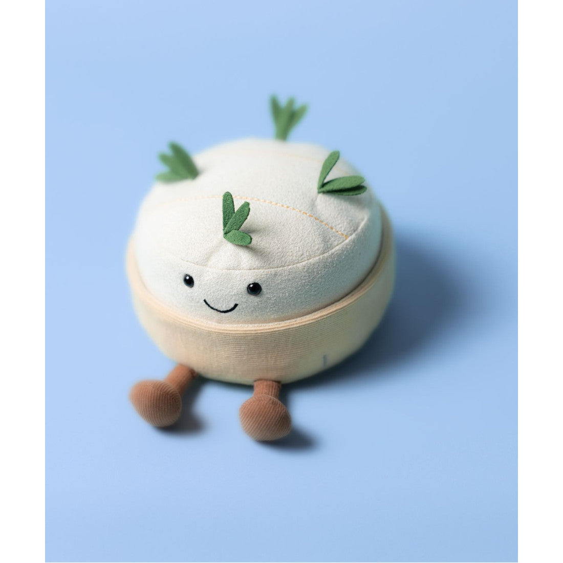 Maskotka Jellycat Amuseables – Camembert 13 cm, na nóżkach, zdjęcie na niebieskim tle